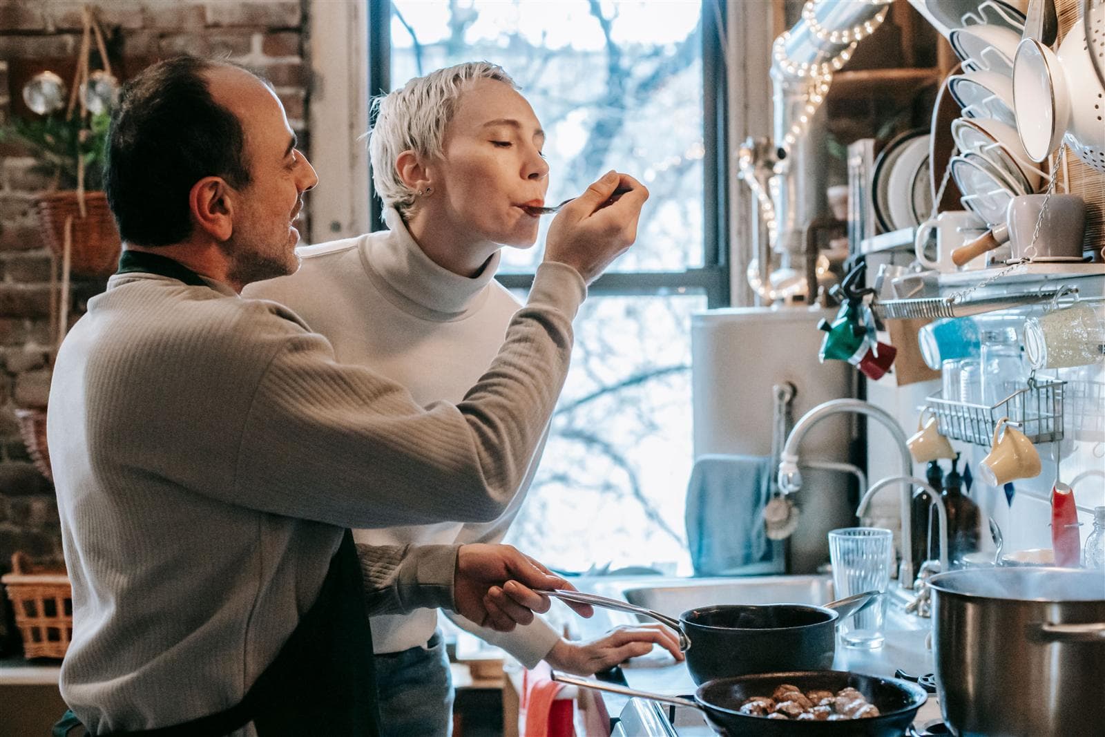 A couple cooking together in a cozy kitchen